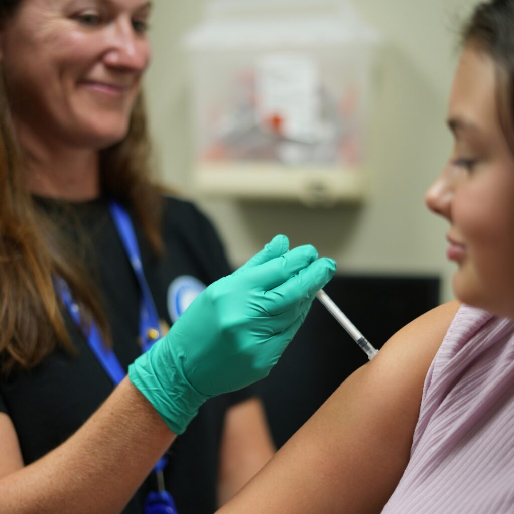 Nurse giving girl a vaccine