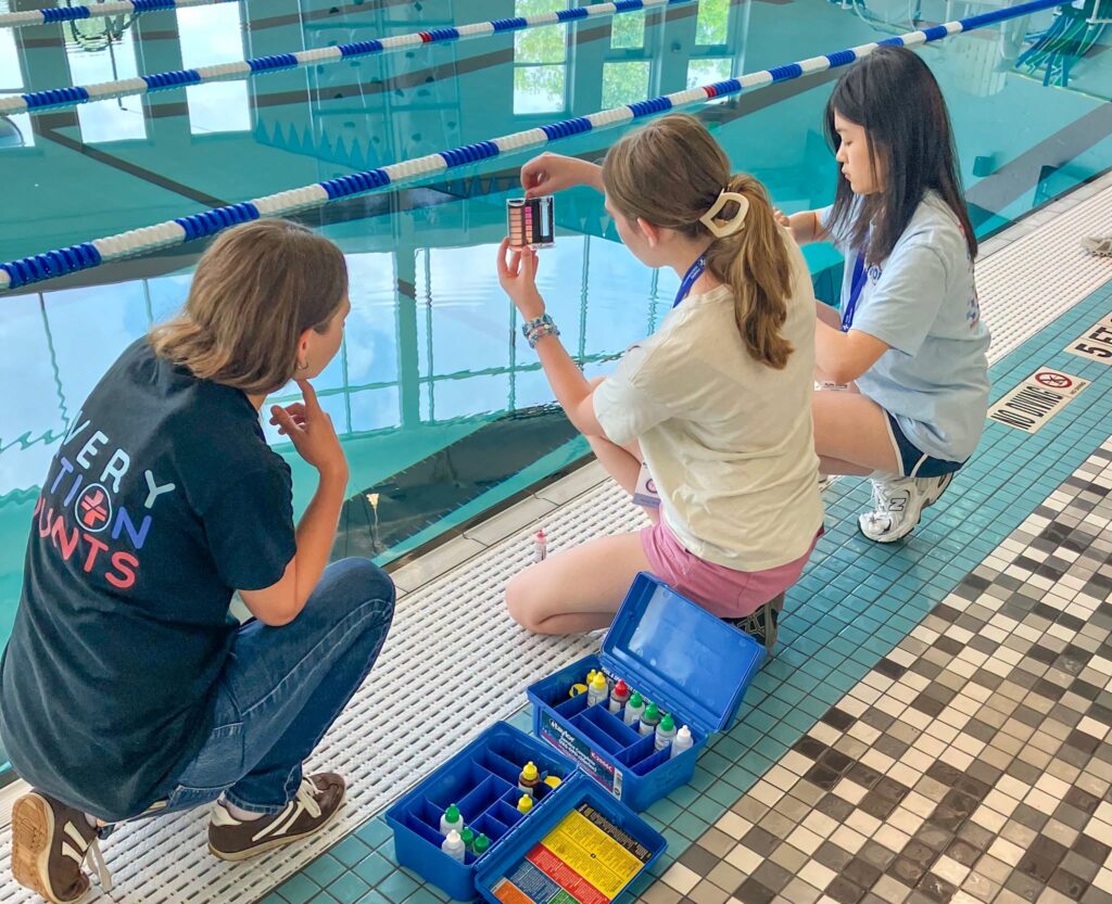 students testing water at pool